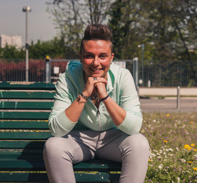 Portrait of a person with hoodie sitting on bench